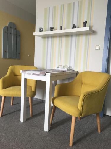 a room with two chairs and a white table and chairs at Hof Kranichstein in Kluis