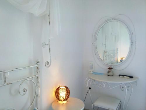a bathroom with a white toilet and a mirror at Villa Le Grand Bleu in Katapola