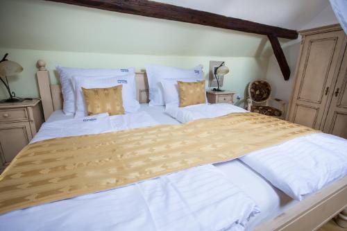 a bedroom with two beds with white sheets and pillows at Pension PREMIUM in Český Krumlov