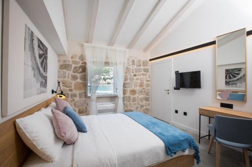 een slaapkamer met een bed, een bureau en een televisie bij Bova Luxury Rooms in Dubrovnik