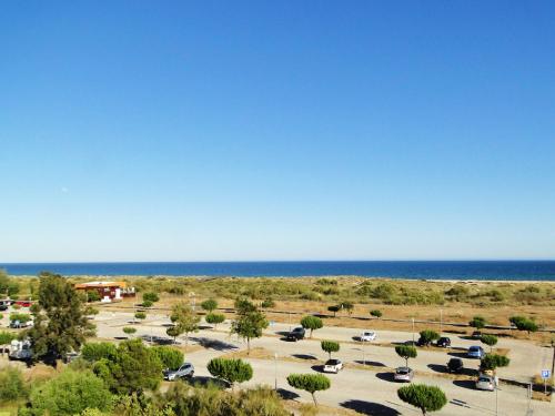 a parking lot with the ocean in the background at Pérola do Oceano in Manta Rota