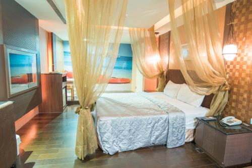 a bedroom with a bed with drapes at 亞歷山大汽車旅館 in Kaohsiung