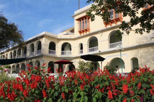 a building with red flowers in front of it at Brijraj Bhawan Palace Hotel in Kota
