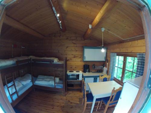 Cabaña de madera con cocina y mesa. en Valldal Camping, en Valldal