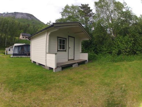 a small white shed in a field of grass at Valldal Camping in Valldal