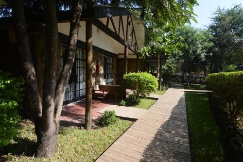 a walkway in front of a building with trees at Acacia Village in Juba