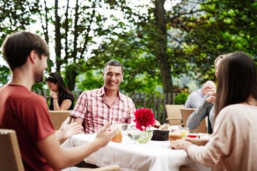 een groep mensen die rond een tafel zitten bij Ganischgerhof Mountain Resort & Spa in Nova Ponente