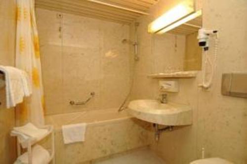 uma casa de banho com um lavatório, uma banheira e um WC. em Apartment in Warmbad Villach em Villach