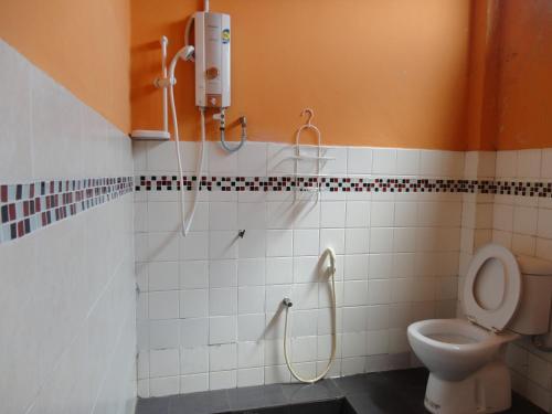 a bathroom with a shower and a toilet at Pristine Hotel in Rawang