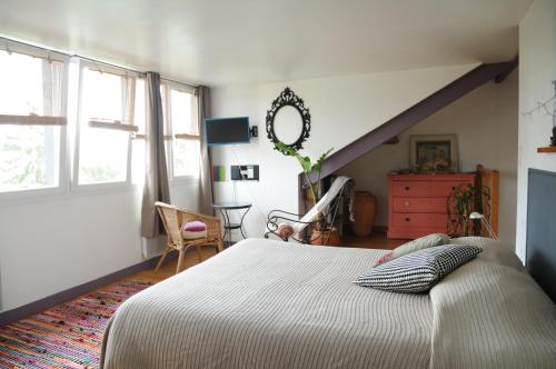 a bedroom with a large bed and a staircase at Annexe 44 in Nantes