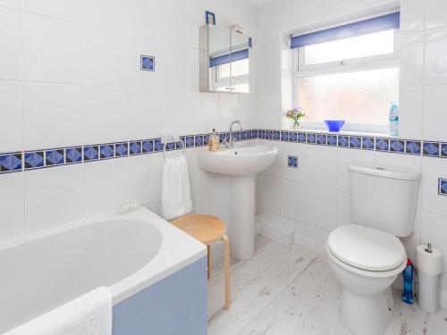 a white bathroom with a toilet and a sink at Walnut Cottage in Aldeburgh