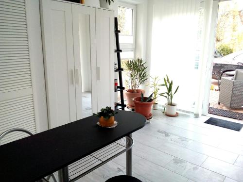 a room with a table and potted plants at Ferienwohnungen am Krossinsee in Berlin