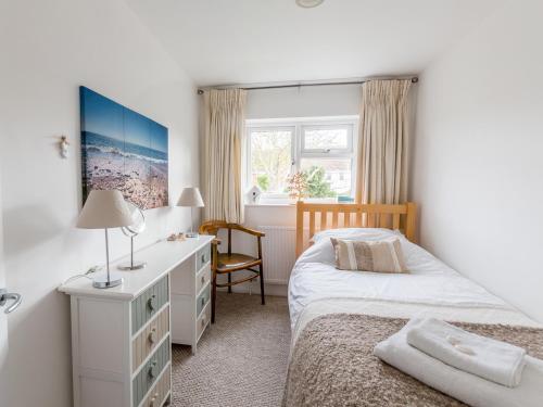 a bedroom with a bed and a dresser and a desk at Walnut Cottage in Aldeburgh