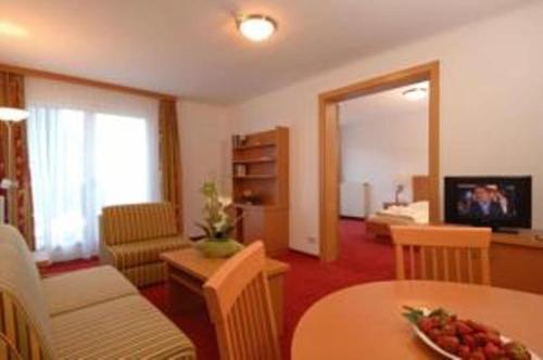 ein Wohnzimmer mit einem Tisch und einem Sofa in der Unterkunft Apartment in Warmbad Villach in Villach