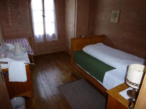 a small bedroom with a bed and a sink at Hotel Waldrand in Kiental