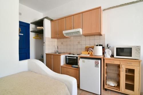 a kitchen with a white refrigerator and a microwave at Standing Stone in Kionia