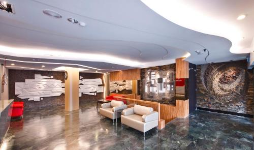 a living room with two white chairs and a wall at Hotel Taiwan Changhua in Changhua City