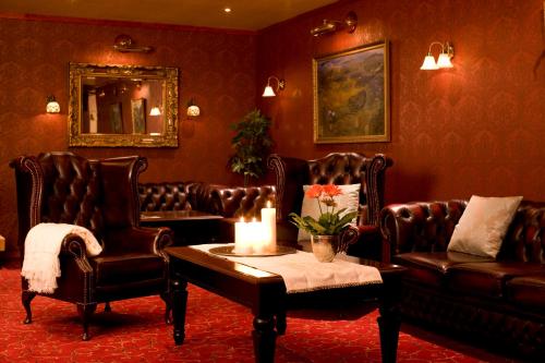 a living room with leather chairs and a candle on a table at Best Western Laegreid Hotell in Sogndal