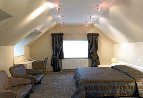 - une chambre avec un lit, une chaise et une fenêtre dans l'établissement Hotel Salons De Vrede, à Ichtegem