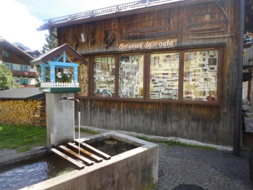 a building with a fountain in front of a store at Sella Ronda Apartment in Campitello di Fassa