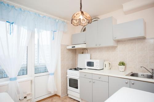 モスクワにあるInnDays on Nakhimovsky Prospektの白いキャビネットと窓付きのキッチン