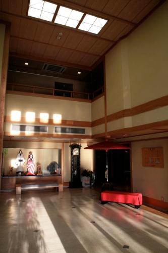 a large empty room with a red bed in the middle at Izumiya Ryokan in Kyoto