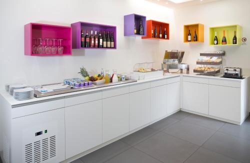a white kitchen with a counter with food and drinks at Love Boat Hotel - The Original in Riccione