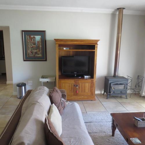 a living room with a couch and a tv at Bella Vista Self Catering in Clarens