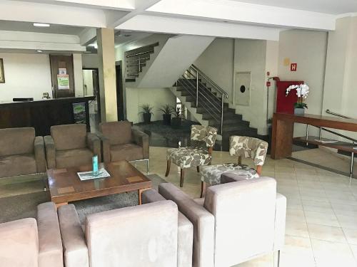 a living room with a couch and chairs and a table at Hotel Mohallem in Passos