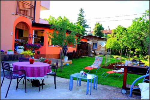un patio con una mesa y sillas y una casa en Apartments Nives NB en Savudrija