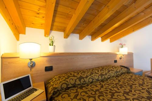 a bedroom with a bed with a laptop on a desk at Hotel Kennedy in Lido di Jesolo