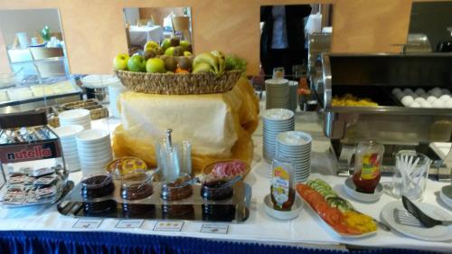 a table topped with a buffet with a bowl of fruit at Hotel Ambiente in Halberstadt