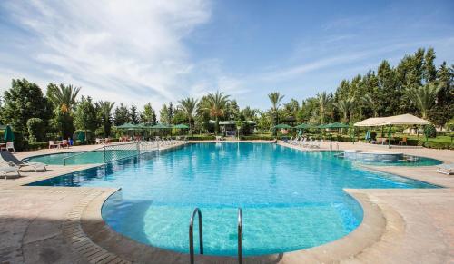 a large pool with blue water in a resort at Zalagh Parc Palace in Fès