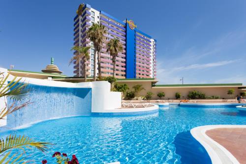 a swimming pool in front of a large building at Paradise Luxury Apartment in Playa Paraiso