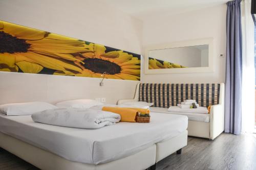 a bedroom with a bed with a painting of a sunflower at Maso Agritur Santa Lucia in Dro
