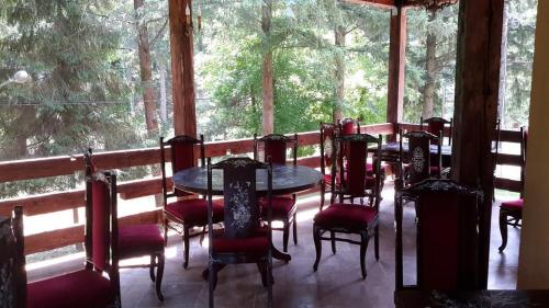 a room with tables and chairs and a large window at Pensiunea Mayumi Moneasa in Moneasa