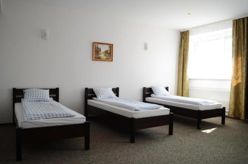 three beds in a room with a window at Willa Sailor Pabianice in Pabianice