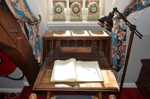 a book on a table with a lamp and clocks at Herberg de Gouden Leeuw in Bronkhorst