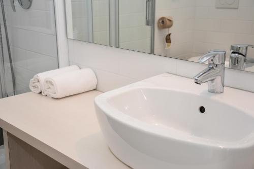 a white bathroom with a sink and a mirror at Maso Agritur Santa Lucia in Dro
