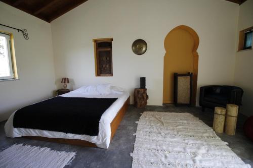 Un dormitorio con una cama, un sofá y una silla. en Dias Distintos - Turismo Rural, en Colos