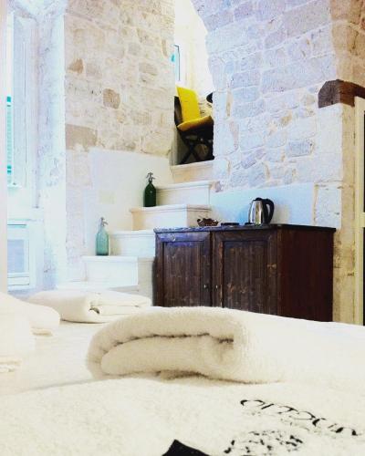 a room with white walls and a stone wall at Le Dimore del Finoglio in Conversano