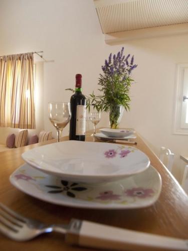 a table with a plate and a bottle of wine at Ostria Village in Mylopotas