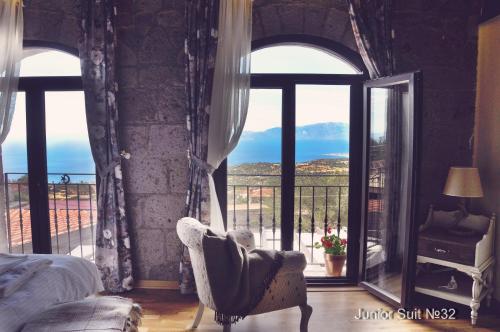 a bedroom with a bed and a large window at Assos Sunaba Kasri Hotel in Behramkale