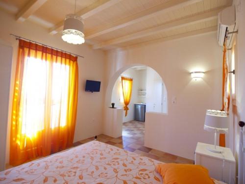 a bedroom with a bed and a large window at Ostria Village in Mylopotas