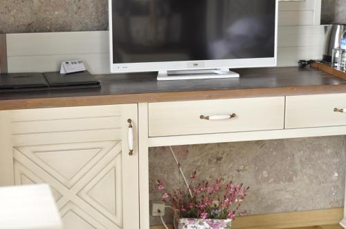 a television sitting on top of a white cabinet at Assos Sunaba Kasri Hotel in Behramkale