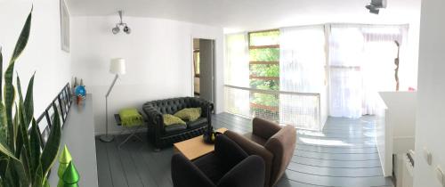 a living room with a couch and chairs and a window at Bed of Roses in Amsterdam