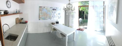 a white kitchen with a desk and a window at Bed of Roses in Amsterdam