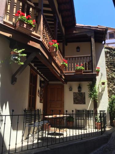 a house with a balcony and tables and chairs at Hostería La Antigua in Potes