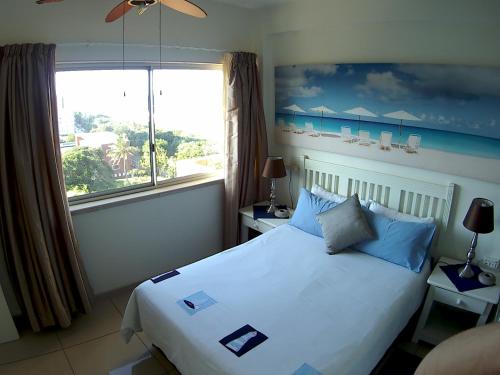 a bedroom with a bed and a large window at Seaview Apartment Amanzimtoti in Amanzimtoti
