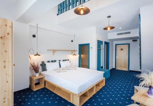 ein Schlafzimmer mit einem großen weißen Bett in einem Zimmer in der Unterkunft Peninsula Resort in Murighiol
